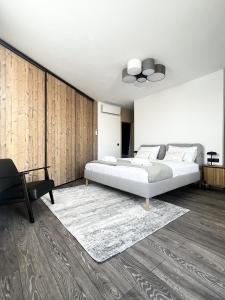 a bedroom with a large bed and a chair at MT SUITES BUDAPEST in Budapest