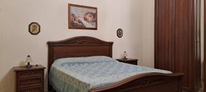 a bedroom with a wooden bed and two night stands at Cinque terrazze - Casa d'epoca con vista mare in Gallipoli
