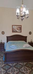 a bedroom with a bed and a chandelier at Cinque terrazze - Casa d'epoca con vista mare in Gallipoli
