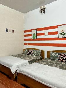 two beds in a room with an american flag on the wall at Đức Long in Vung Tau