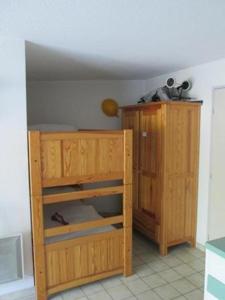 a wooden cabinet in a room with a shelf at Vittoria Immobilier 3 - Vue Dégagée - Terrasse - chèques vacances acceptés in La Grande Motte