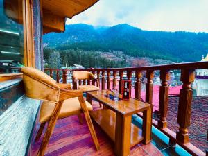 una silla y una mesa en un balcón con vistas en Kawayat INN, en Bhavnagar