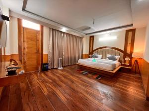 1 dormitorio con 1 cama y suelo de madera en Kawayat INN, en Bhavnagar
