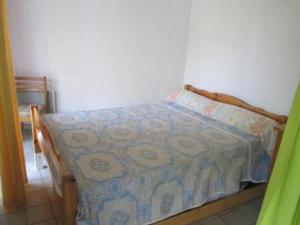 Un dormitorio con una cama con una manta. en Vittoria Immobilier 3 - REGLEMENT SUR PLACE - chèques vacances acceptés, en La Grande-Motte