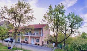 a pink house with a porch and a balcony at Apartment Jasna in Jasenak
