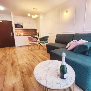 a living room with a blue couch and a table at Continental Apartament przy plazy in Krynica Morska