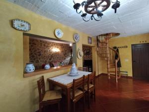 a dining room with a table and chairs and a chandelier at Casa do Terreiro in Cujó