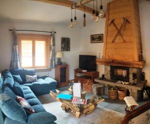 uma sala de estar com um sofá azul e uma lareira em Superbe chalet 10 personnes 5 chambres Les Houches em Les Houches