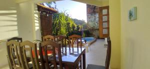 a dining room with a table and chairs and a window at CACAU HOSTEL & SUITES in Morro de São Paulo