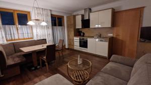 een keuken en een woonkamer met een bank en een tafel bij Oberstockerhof in Sankt Johann im Pongau