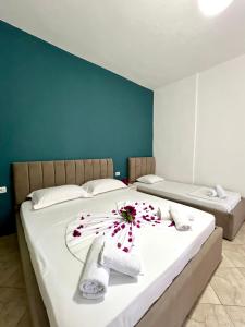 a bedroom with two beds with a flower on the bed at Flower Garden Villa in Ksamil