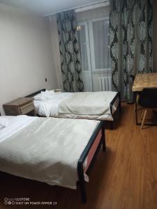 a hotel room with two beds and a table at tsogoo's geust house in Ulaanbaatar