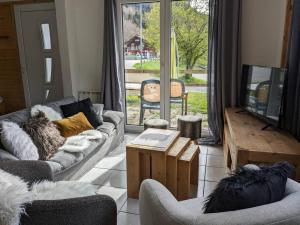sala de estar con sofá, sillas y TV en Spacieux T3 terrasse en rez coeur de station, en Bernex