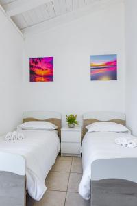 two beds in a room with two paintings on the wall at Il trentanove in Valeggio sul Mincio