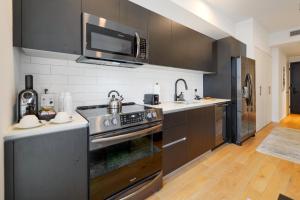uma cozinha com um fogão e um lavatório em Incredible High-Floor Studio with Bay Views em Miami
