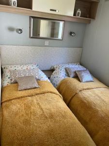 a bedroom with two beds with pillows on it at Seabreeze, Utopia, Shorefield Country Park, Milford on Sea, Shorefield Road, SO41 0LH, United Kingdom in Milford on Sea