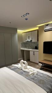 una camera da letto con un letto e asciugamani bianchi di Hotel AL-REEM a Al Ula