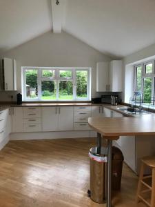 cocina con armarios blancos y mesa de madera en Fully accessible Hampshire Home en Waterlooville