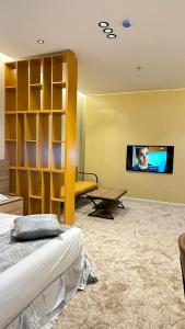 um quarto com uma cama e uma televisão na parede em Hotel AL-REEM em Al-ʿUla