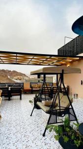 patio con tavolo e sedie sul tetto di Hotel AL-REEM a Al Ula