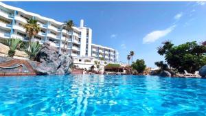 a swimming pool in front of a large building at Golf vila3 in San Miguel de Abona