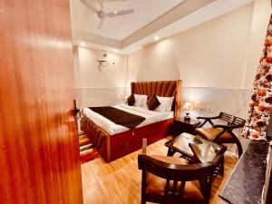 1 dormitorio con 1 cama, mesa y sillas en Samantha Guest House, en Bhavnagar