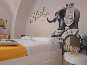 1 dormitorio con 1 cama con un elefante en la pared en U Liotru home, en Catania