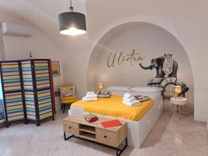 a bedroom with a bed and an elephant sign on the wall at U Liotru home in Catania