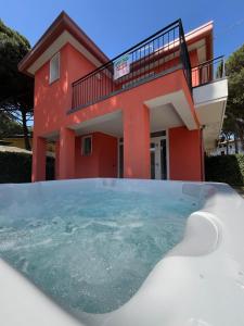 une maison avec un bain à remous en face d'une maison dans l'établissement Principesse, à Rosolina Mare