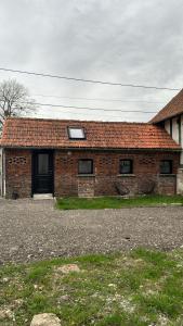Colline-BeaumontにあるGîte à la fermeの赤レンガ造りの家(黒いドアと窓付)