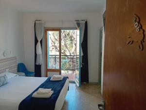 サン・ビセンツ・デ・モンタルトにあるHostal Santa Gemmaのベッドルーム1室(ベッド1台付)、バルコニーへのドアが備わります。