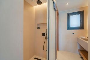 a shower with a glass door in a bathroom at Ocean Rythm Elounda Suite in Elounda +17 photos