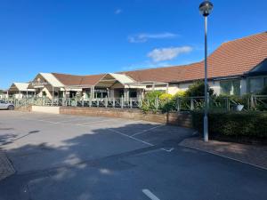 a parking lot in front of a building at Seabreeze, Utopia, walking distance to beach, 5 Star Shorefield Country Park, Milford on Sea, Shorefield Road, SO41 0LH, United Kingdom in Milford on Sea