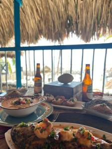 a table with plates of food and bottles of beer at Palenque Beach House in San Onofre