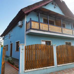 une maison bleue avec une clôture en bois devant elle dans l'établissement REMINA, à Sulina