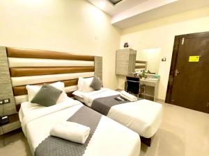 a hotel room with two beds and a mirror at Hotel Sky International- Airport Zone Hyderabad in Shamshabad