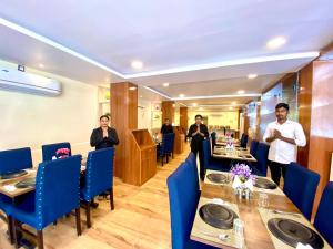 un grupo de personas de pie en un restaurante en Hotel Sky International- Airport Zone Hyderabad en Shamshabad