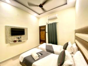 a bedroom with two beds and a ceiling fan at Hotel Sky International- Airport Zone Hyderabad in Shamshabad