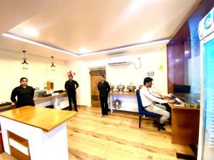 Hotel Sky International- Airport Zone Hyderabad في شامشاباد: مجموعة أشخاص واقفين في مطبخ مع طاولة
