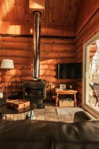Cabaña de madera con sala de estar con fogones. en Le Petit Domaine Caché - Lac-Simon, en Lac-Simon