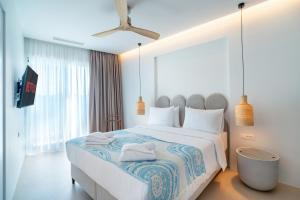 a bedroom with a large bed with towels on it at Ocean Rythm Elounda Suite in Elounda