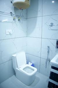 La salle de bains blanche est pourvue de toilettes et d'un lavabo. dans l'établissement D’SHIEKHS RESORT GUREZ, à Kanzalwan