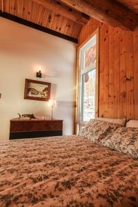 Un dormitorio con una cama grande y una ventana en Le Petit Domaine Caché - Lac-Simon, en Lac-Simon