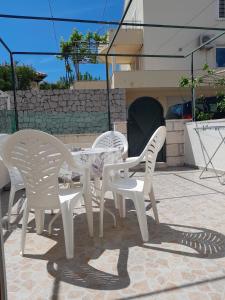 3 sillas blancas y una mesa en el patio en Apartments Marin Tomas, en Dubrovnik
