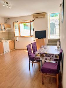 sala de estar con mesa y sillas moradas en Apartments Marin Tomas, en Dubrovnik