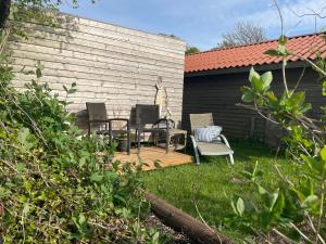 d'une terrasse avec 2 chaises et une table dans la cour. dans l'établissement Nygaard B&B, à Nørre Nebel