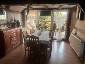 a dining room with a table and chairs and a kitchen at Agroturystyka Bogusław X in Jezierzany