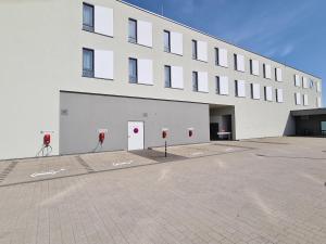 a large white building with a parking lot in front of it at KELKO 1A Hotel in Kehl am Rhein