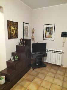 a living room with a television and a desk at Turi house in Messina