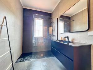 a bathroom with a sink and a mirror at Moradia Uriel in Santa Cruz +32 photos